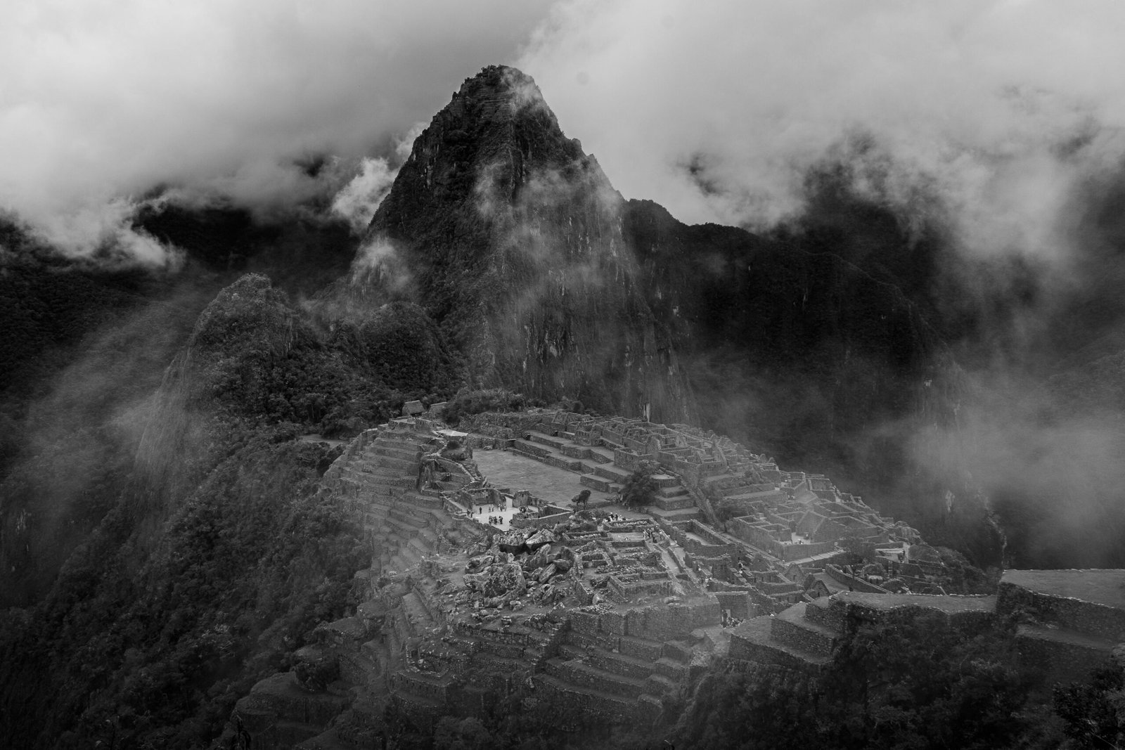 A captivating black and white aerial shot of Machu Picchu shrouded in mist, showcasing its historical allure.